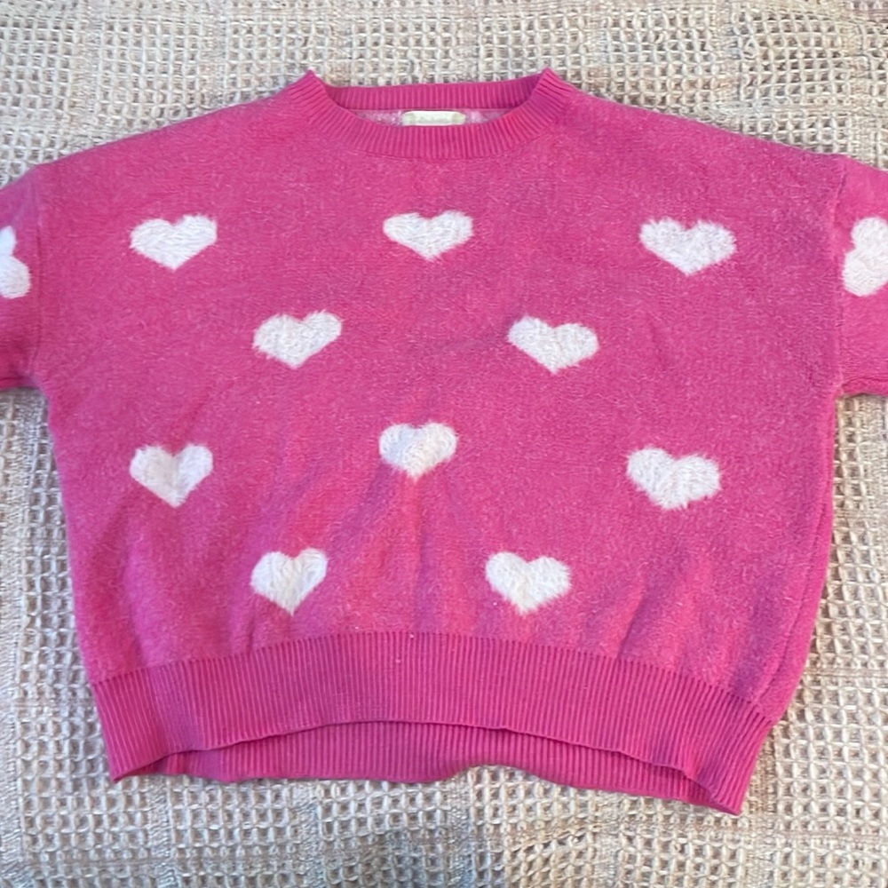 Hot pink sweater with white hearts.